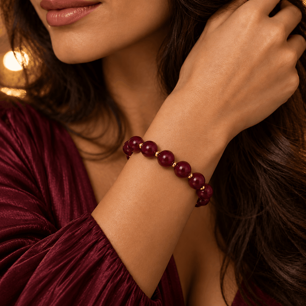 Bordeauxrode kralenarmband gedragen om de pols