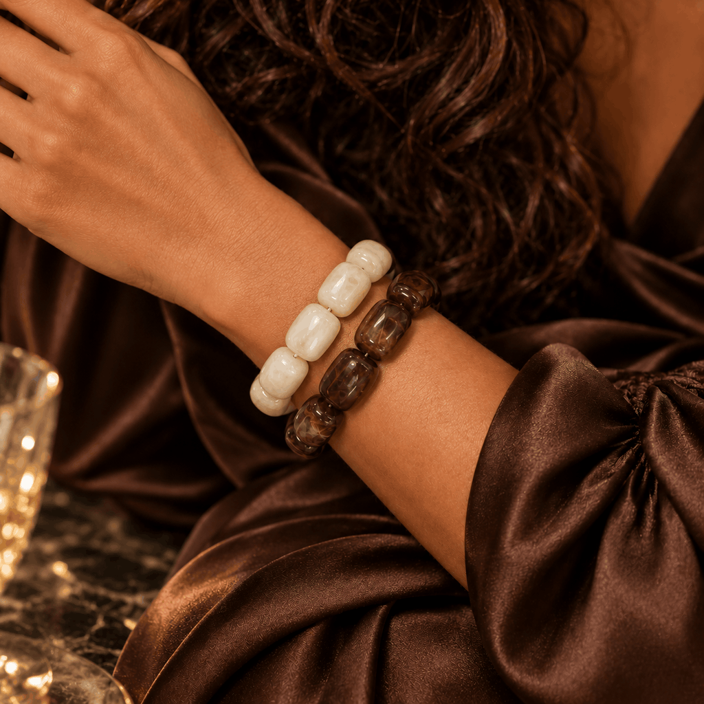 Luxe kralenarmbanden in warme bruintinten gedragen om de pols