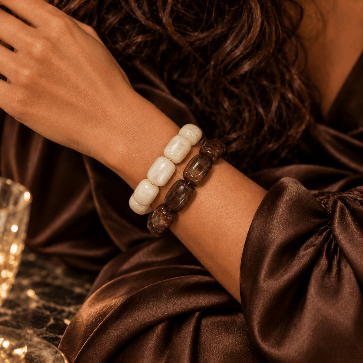 Luxe kralenarmbanden in warme bruintinten gedragen om de pols