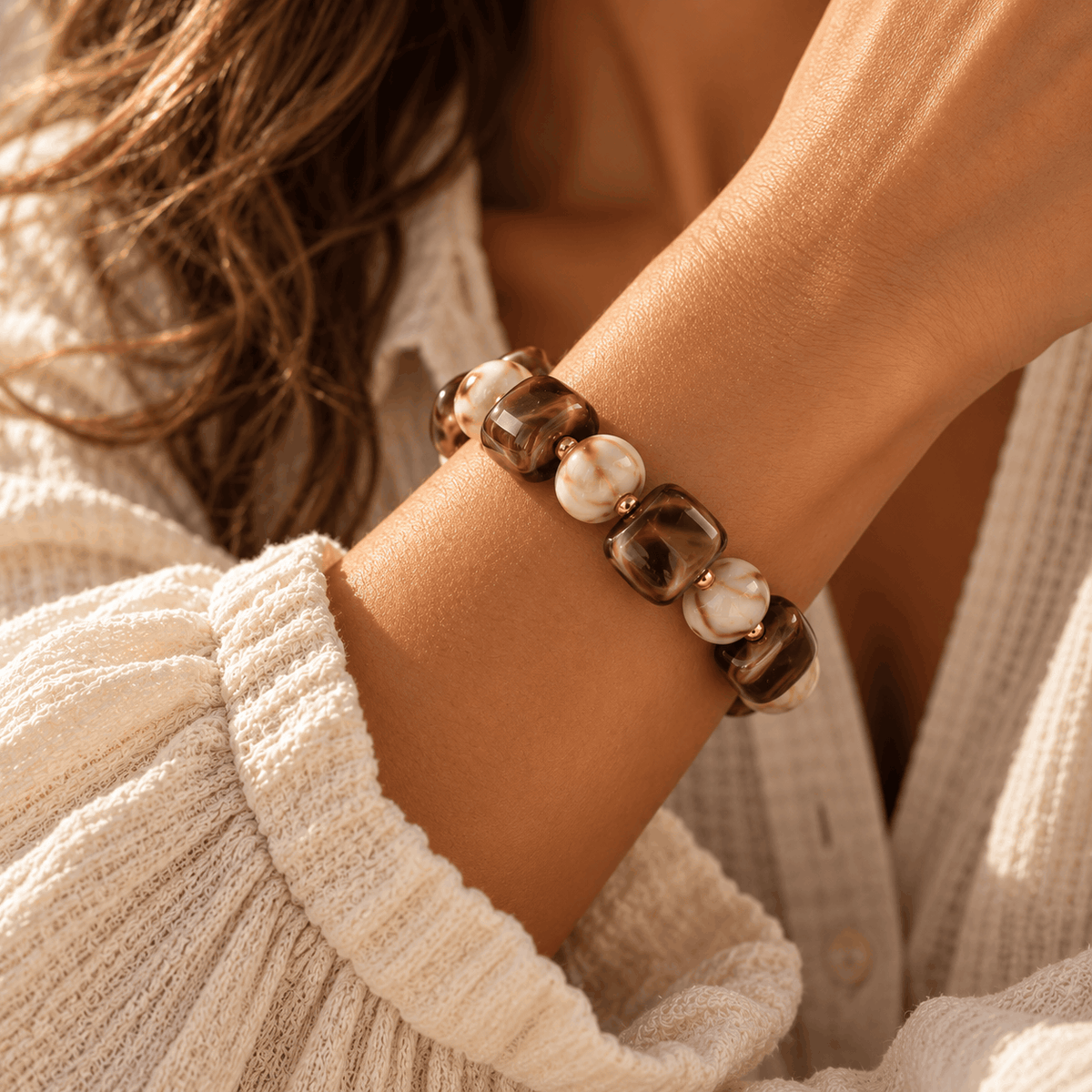 Bruin-crème Nina kralenarmband met goudkleurige details gedragen om de pols van Hippe Kraal