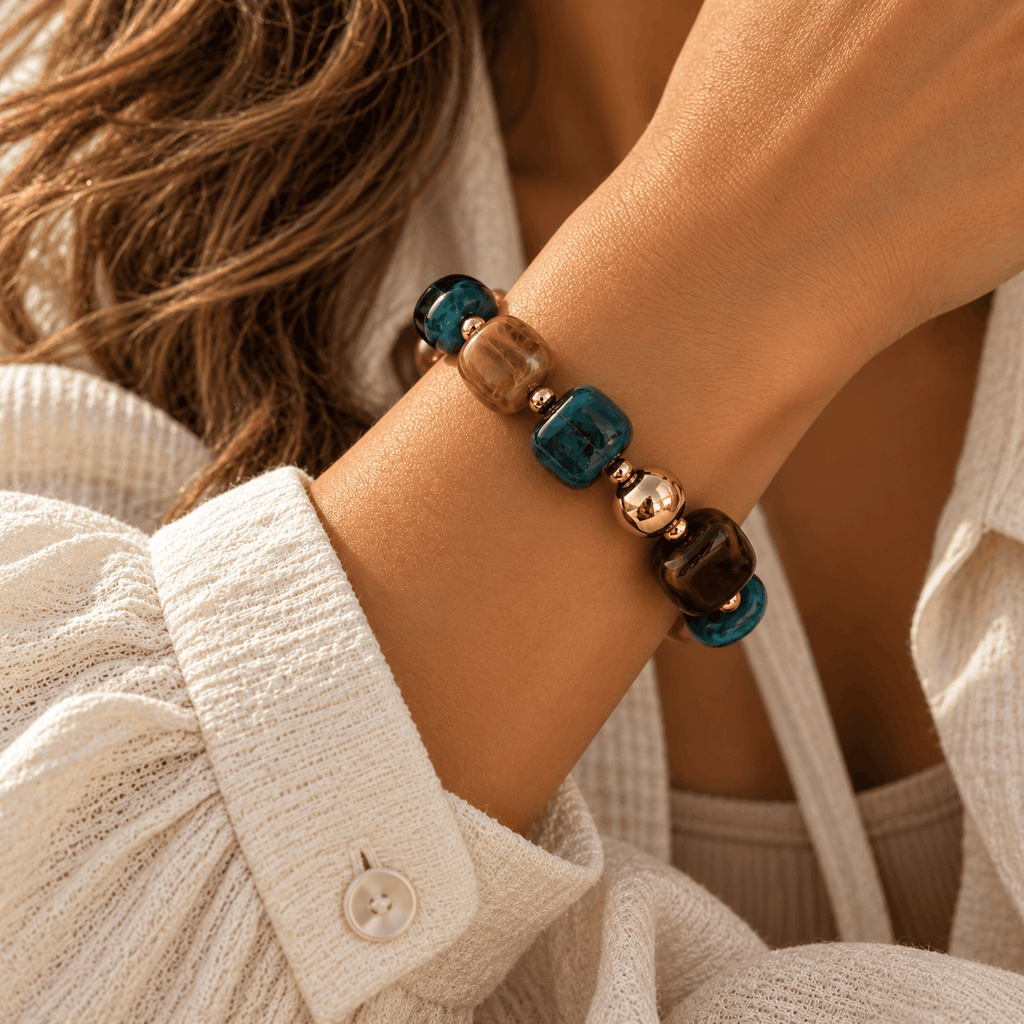 Blauwe Nola kralenarmband met goudkleurige details gedragen om de pols van Hippe Kraal
